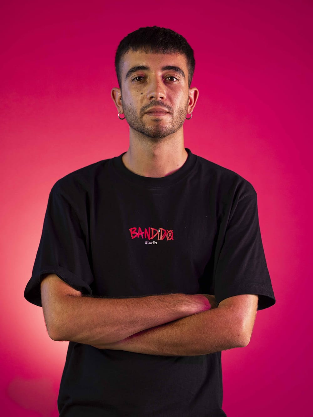 Retrato de Eric sobre fondo rosa, con la camiseta de Bandido Studio
