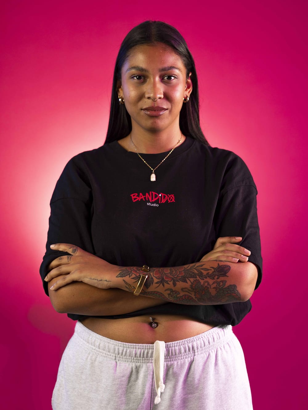 Retrato de Nelly sobre fondo rosa, con la camiseta de Bandido Studio